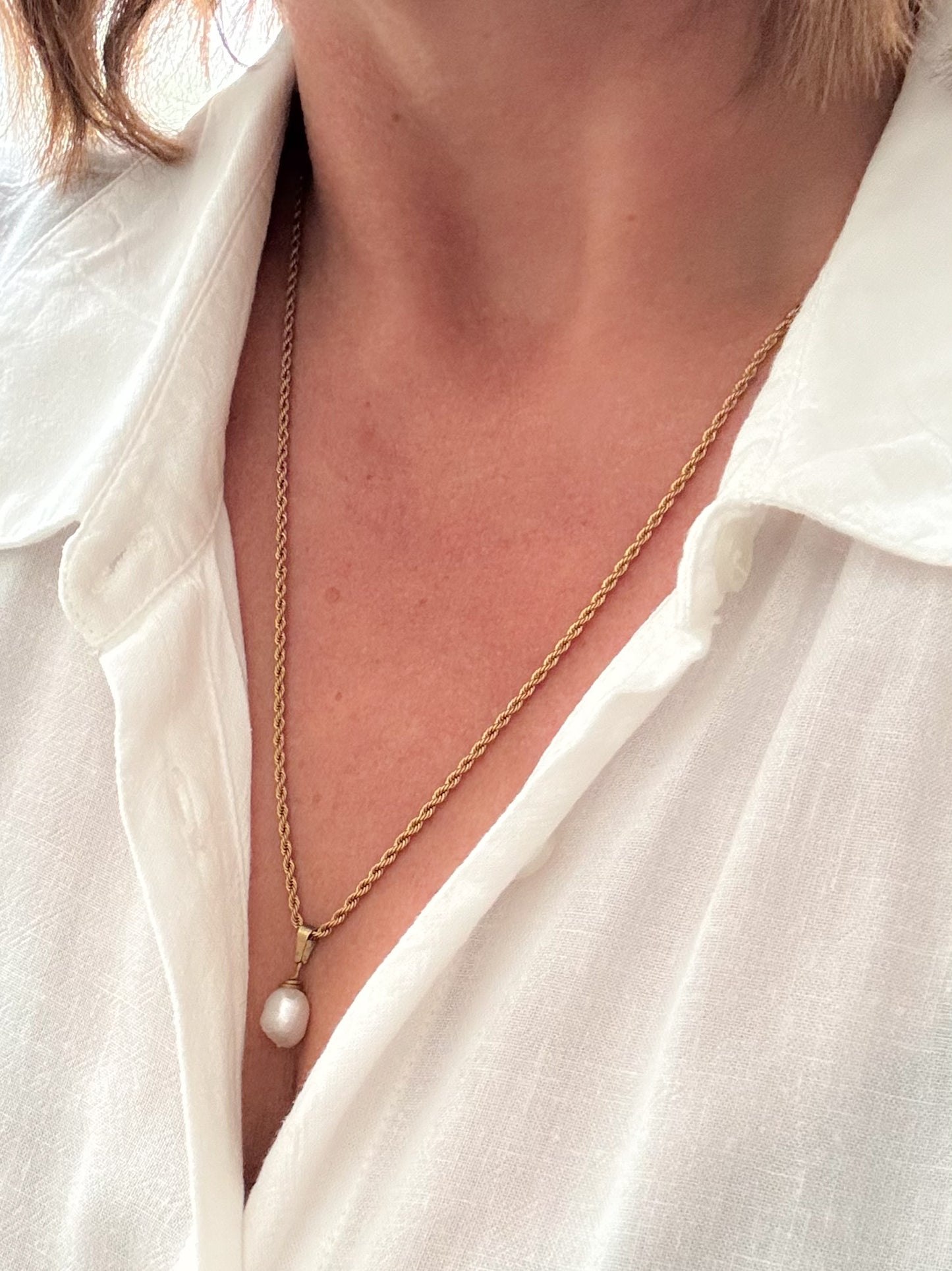 dame met gouden ketting met witte parel