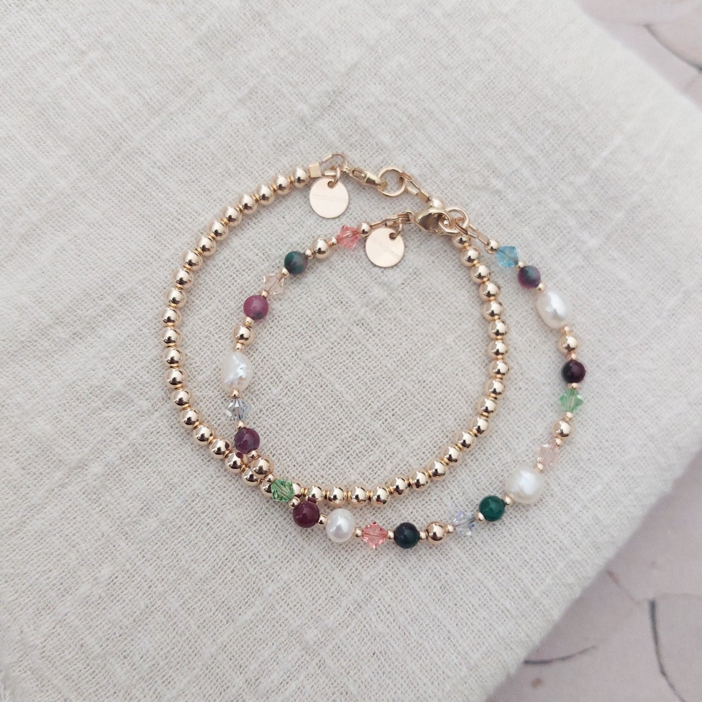 kralen armband samen met een gouden armband met natuurfsteen