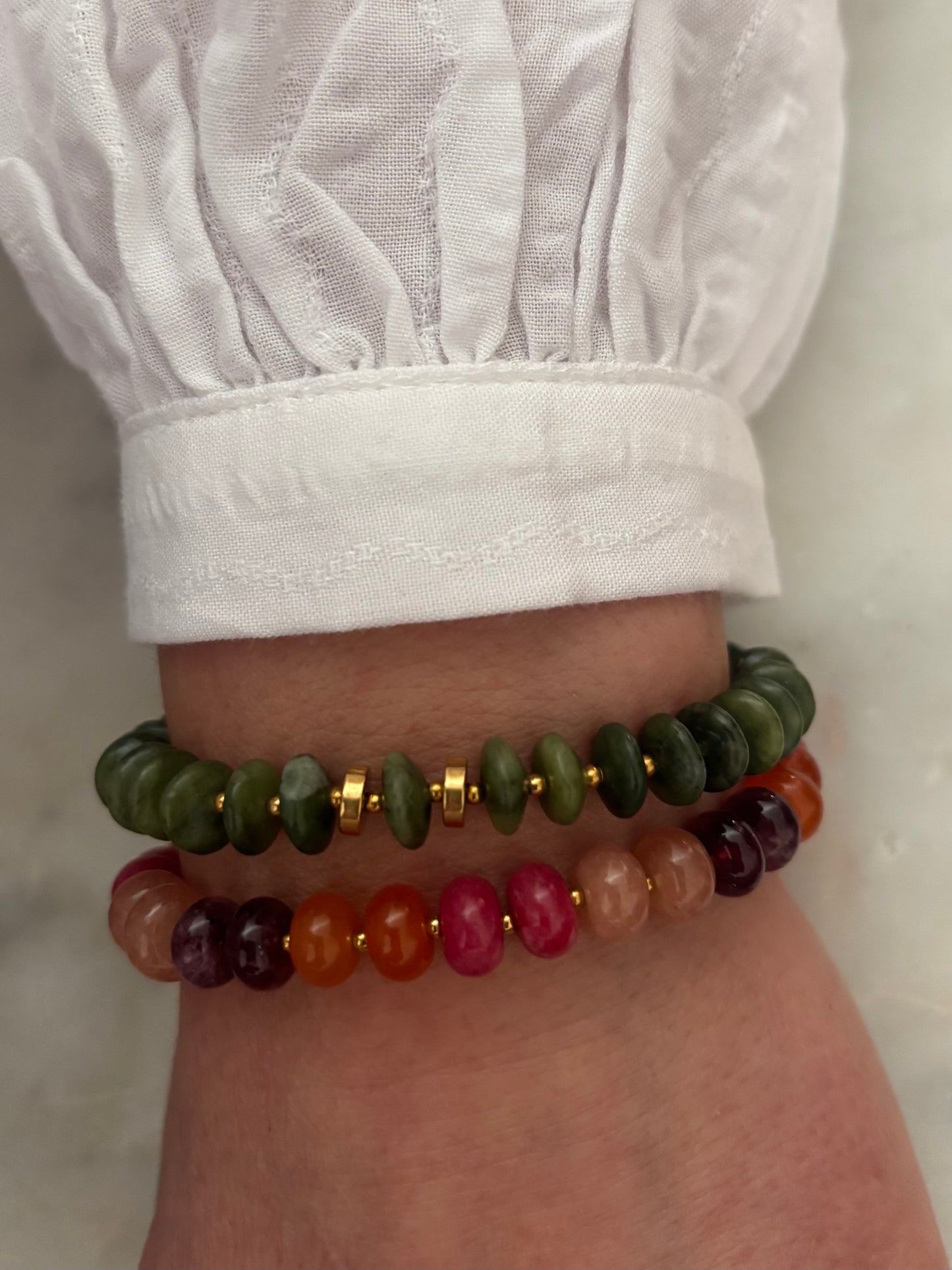 pols met natuurstenen kleurrijke en groene armband en goud rvs