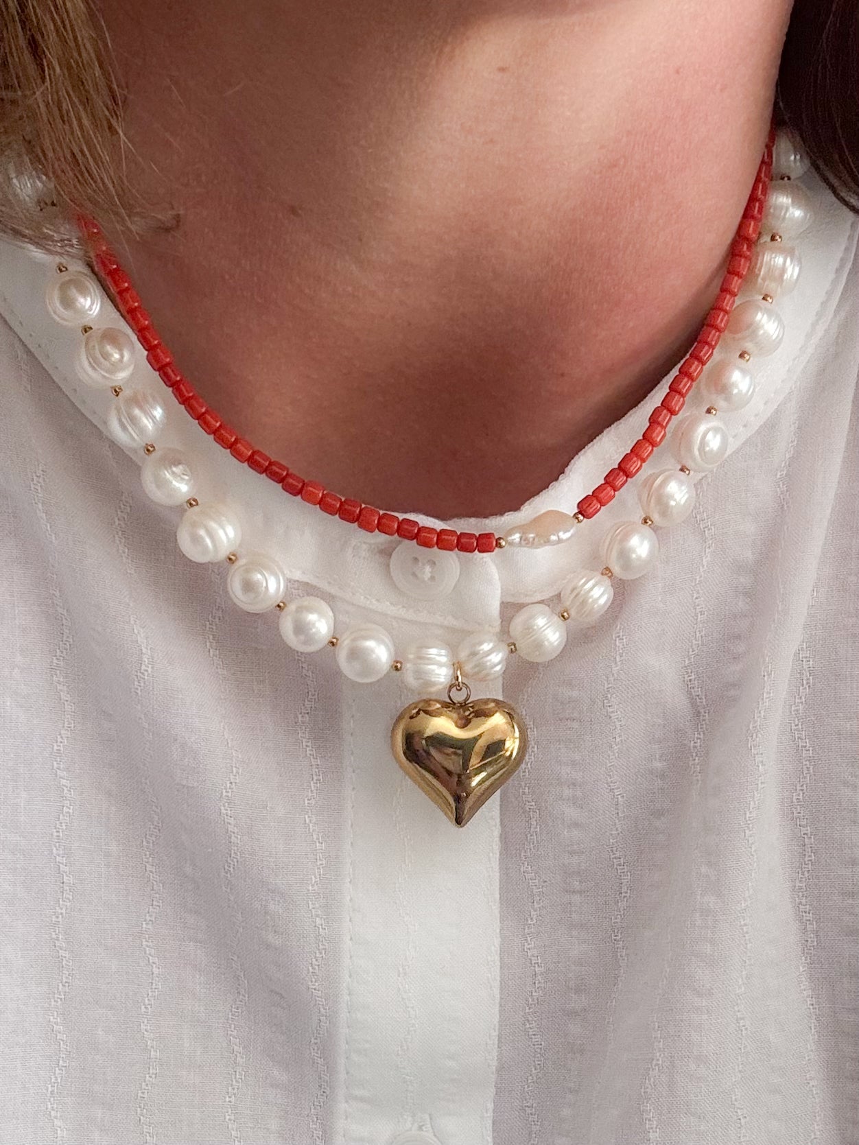 Vrouw met rvs gouden parel ketting met hart bedel